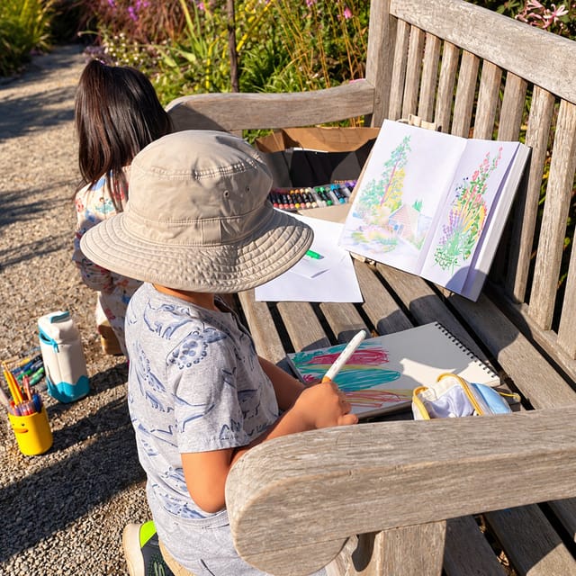 Young artists sketching on a garden bench